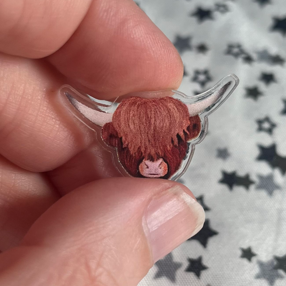 An illlustrated highland cow printed on to clear acrylic